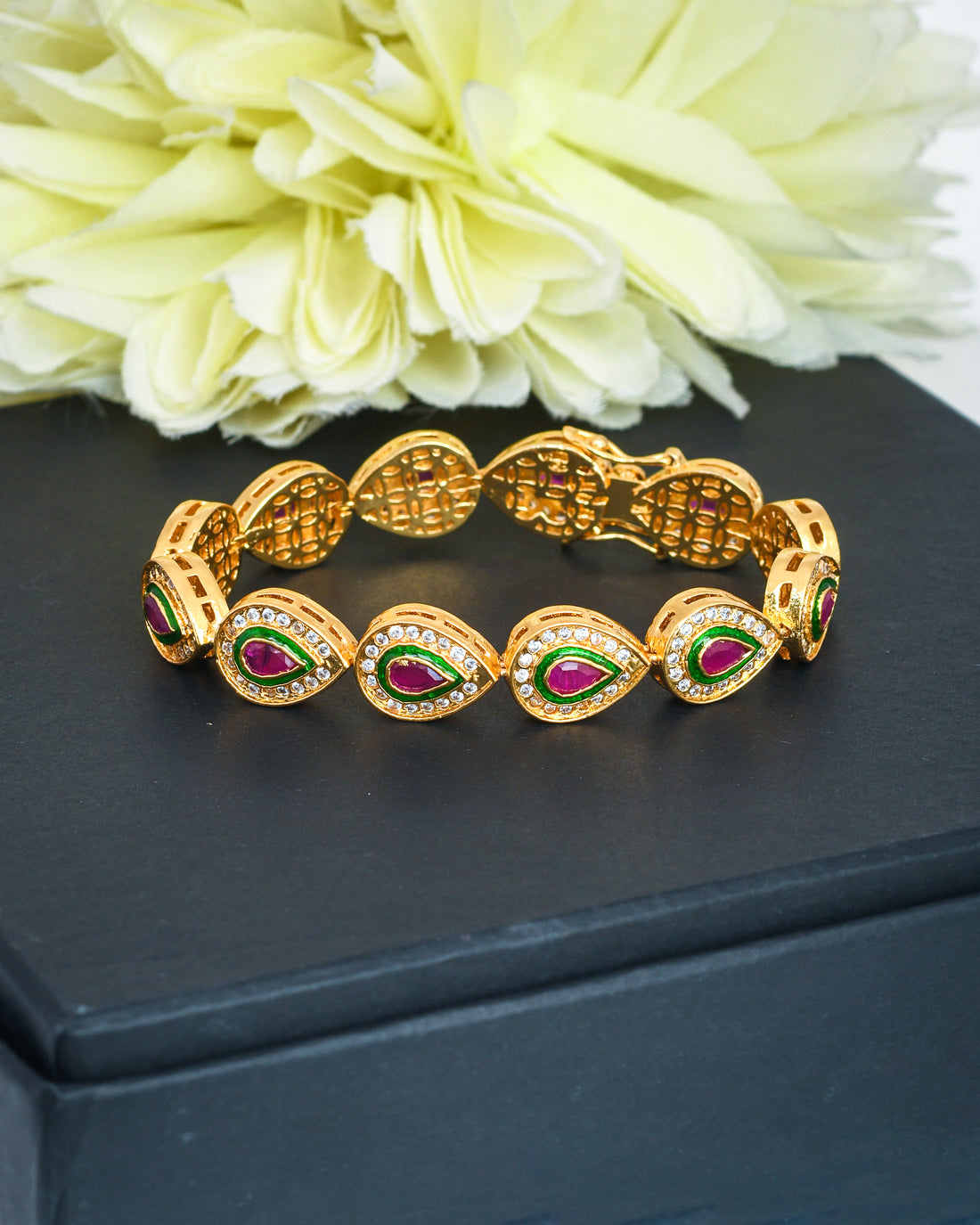 Designer clasp bracelet in antique gold featuring CZ stones and red hydro quartz – perfect for festive wear
