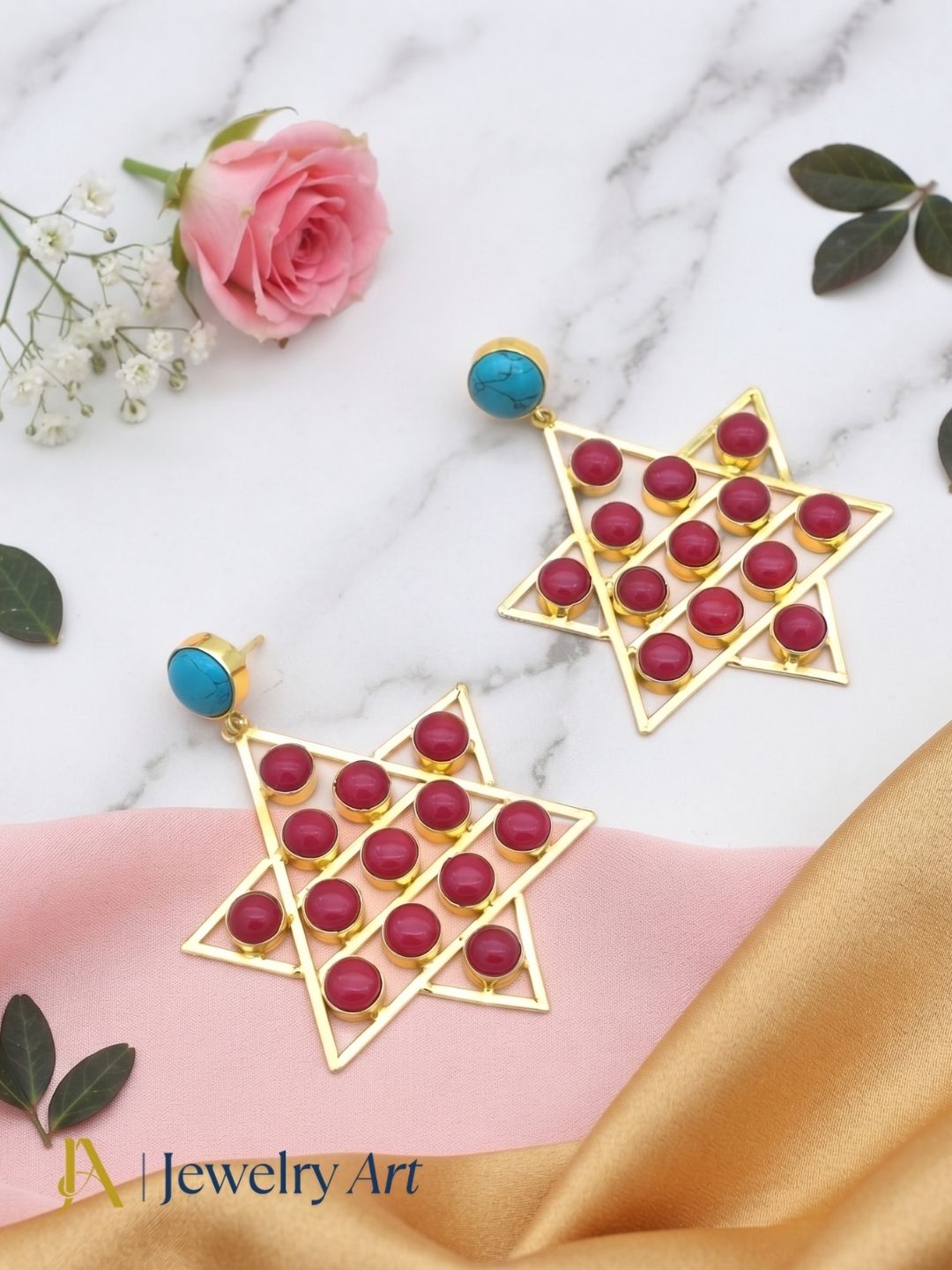 Decorative setup highlighting gold plated Synthetic Turquoise Red Glass gemstone earrings
