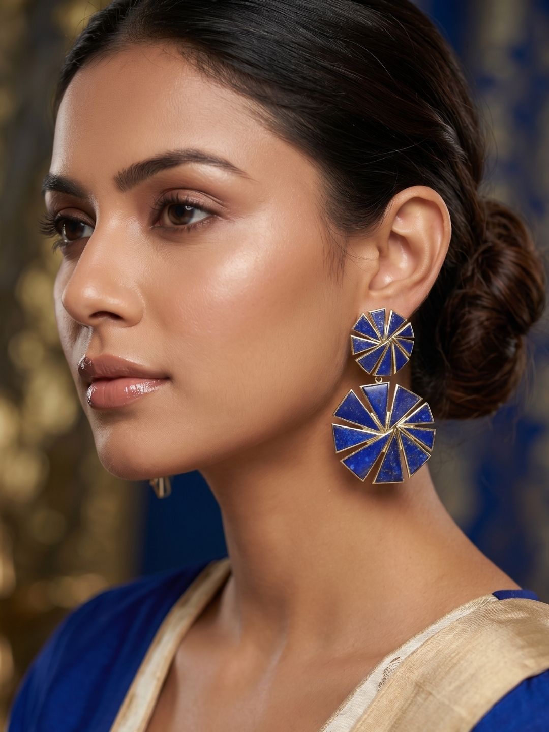 Woman wearing designer gold plated lapis fine geometric chip stone lightweight dangle earrings.
