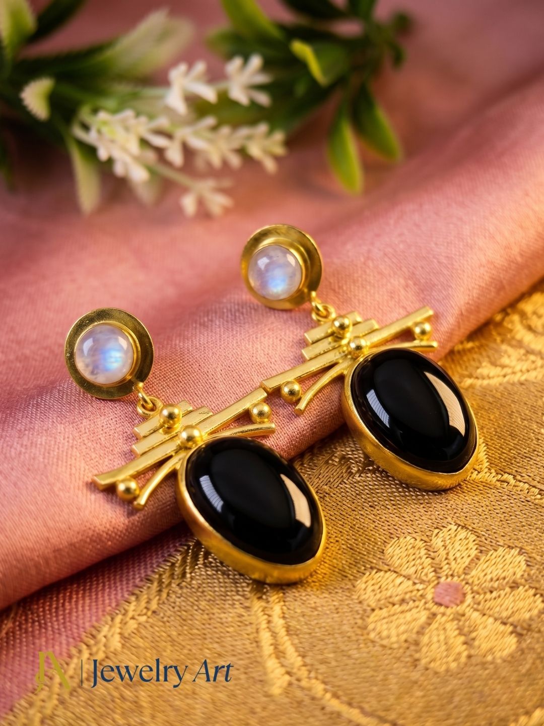 Contemporary black onyx white rainbow earrings in a creative jewelry arrangement
