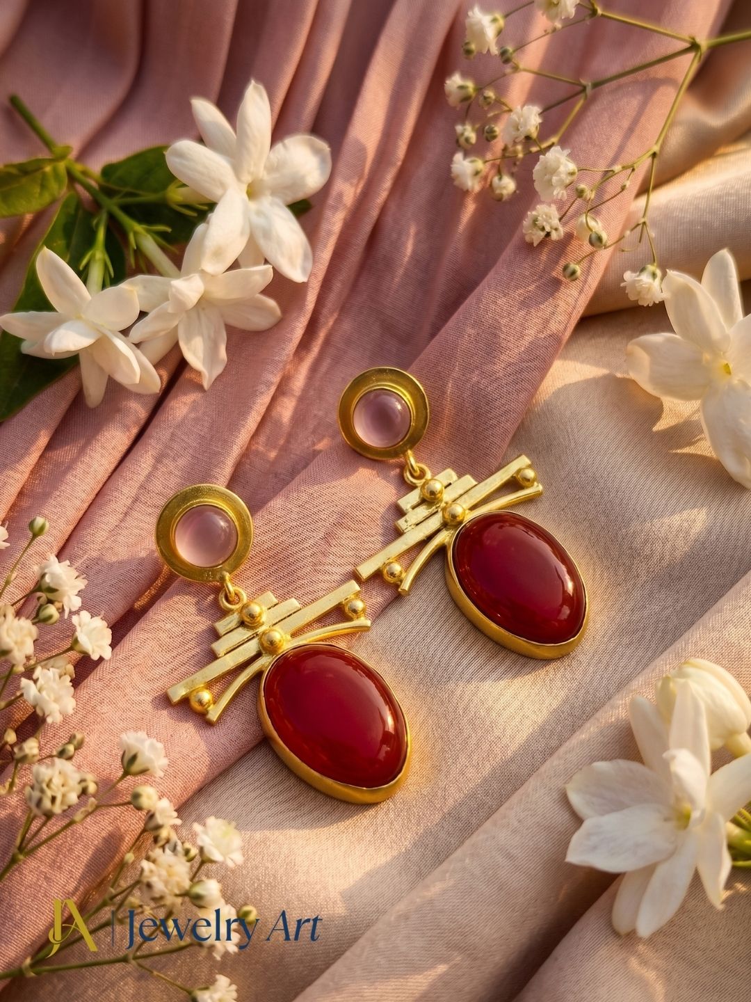 Rose quartz red onyx gemstone earrings displayed with luxury decorative props
