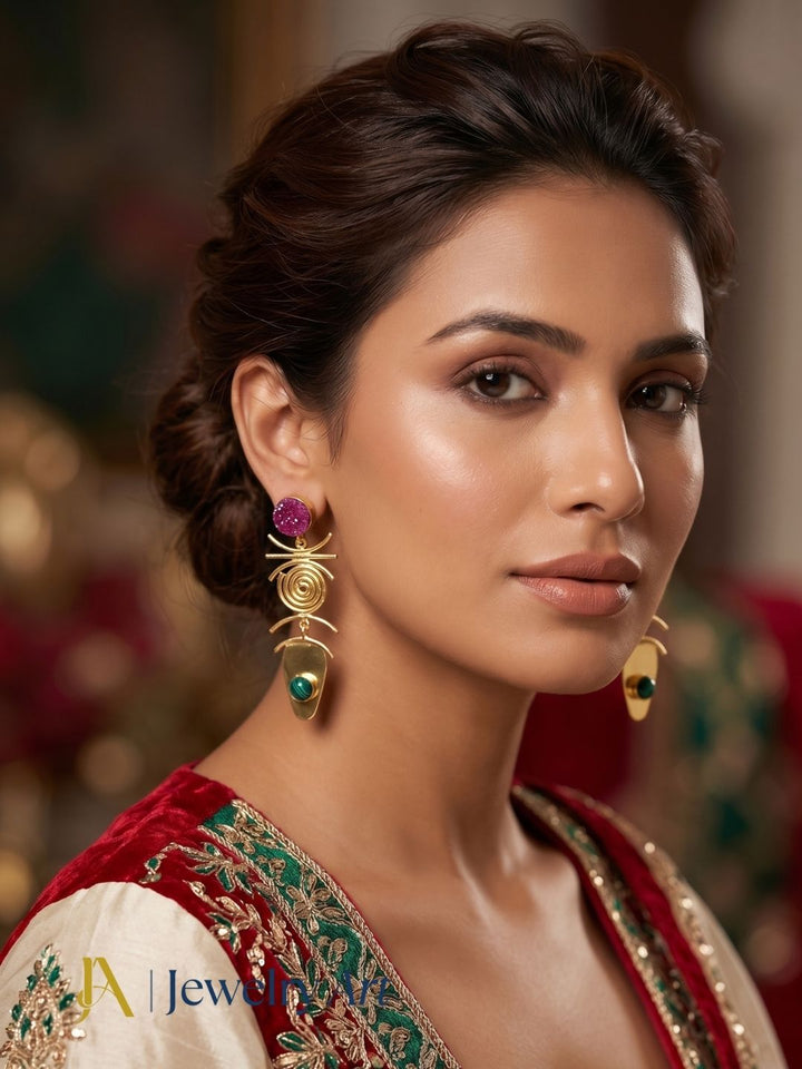 Woman wearing designer gold plated red druzy and synthetic malachite dangle earrings.
