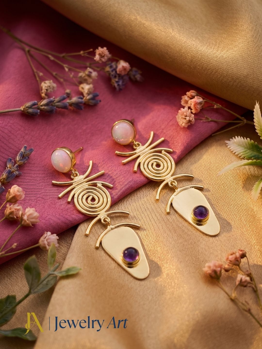 Pink opal amethyst gemstone earrings displayed with luxury decorative props
