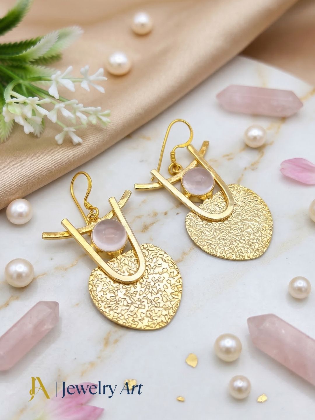 Fashion gold tone dangle earrings with hammered look and rose quartz accent
