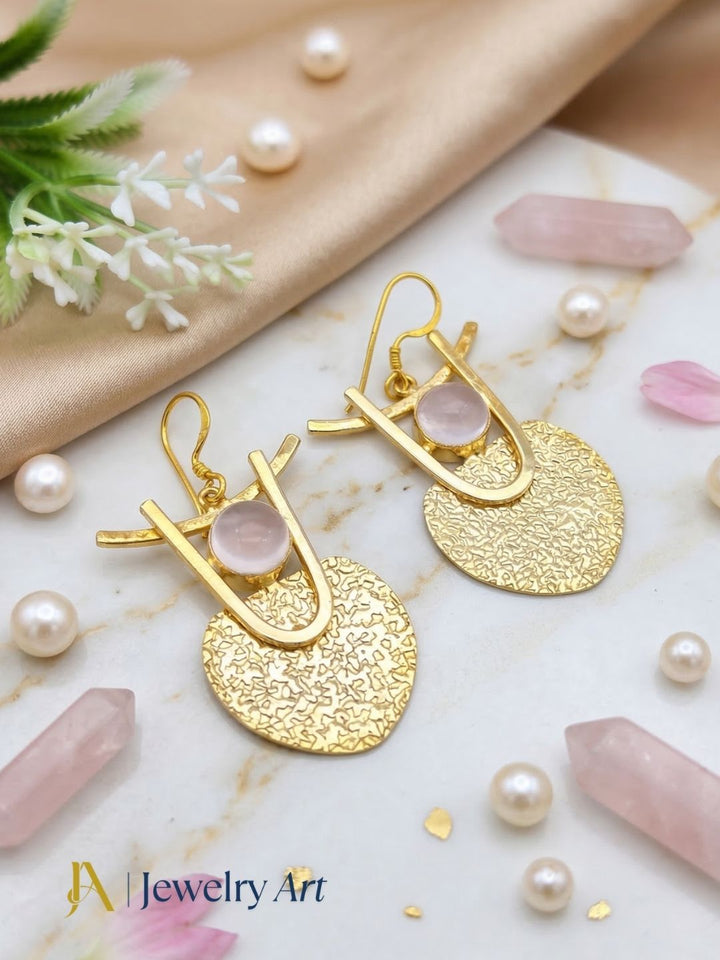 Fashion gold tone dangle earrings with hammered look and rose quartz accent
