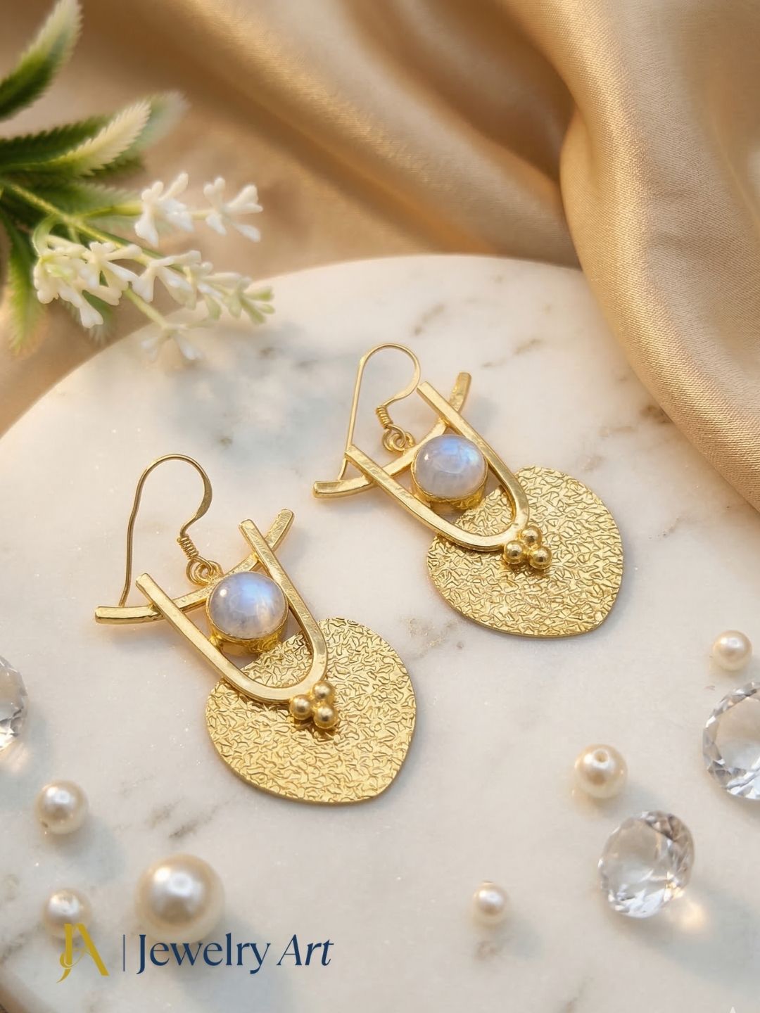 Stylish gold tone earrings with white rainbow and glossy reflective finish
