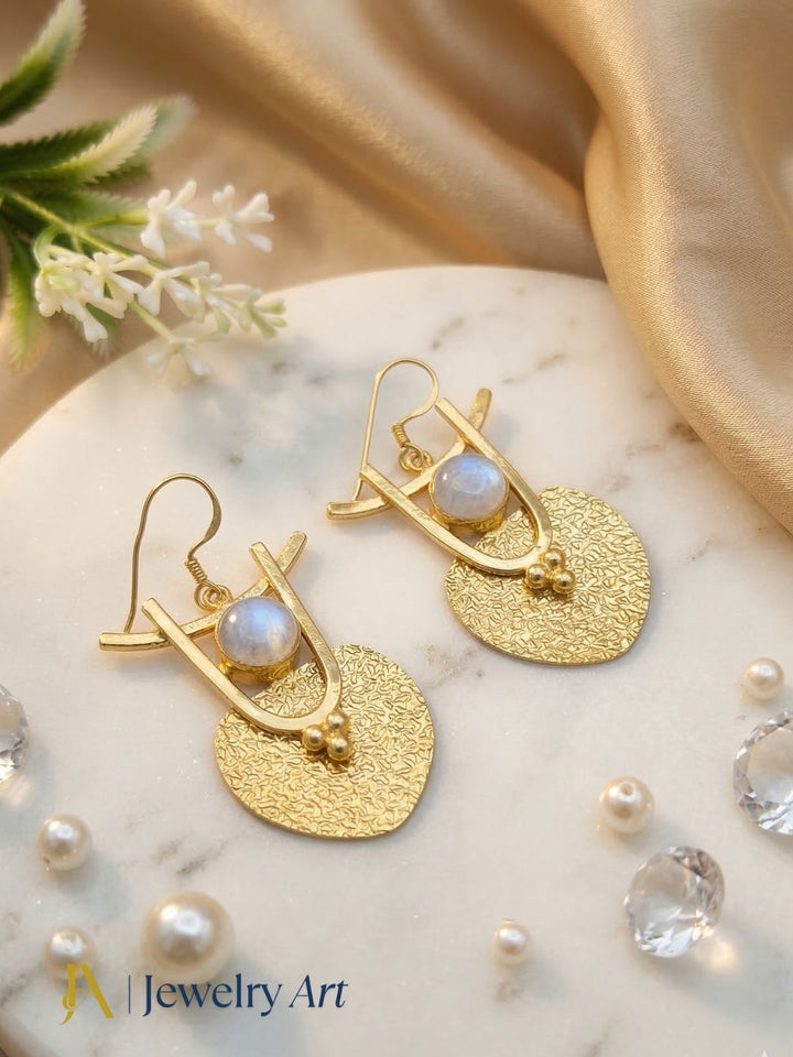 Stylish gold tone earrings with white rainbow and glossy reflective finish
