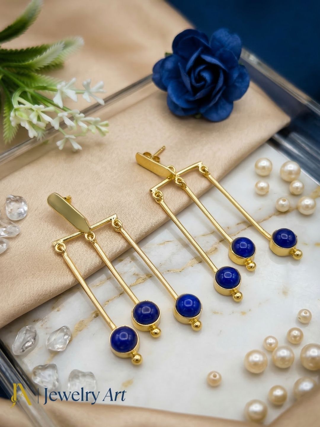 Luxury gold plated drop earrings with vibrant blue glass stone detail
