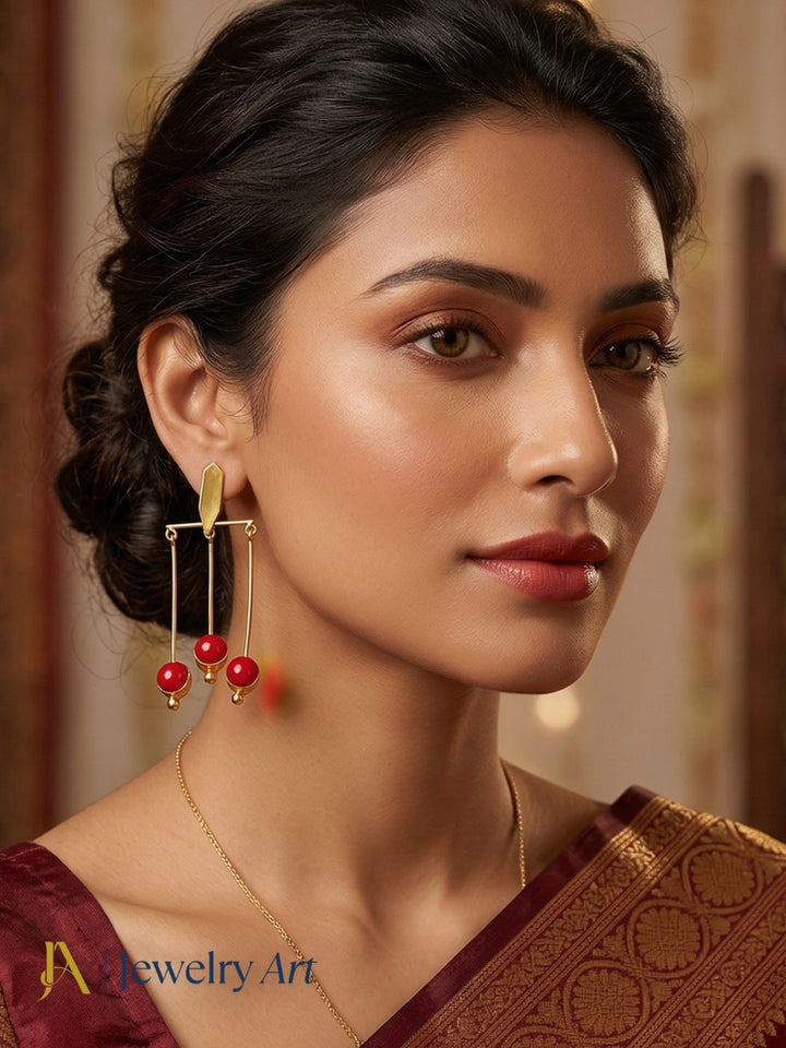 Gold tone drop earrings with red glass stone showcasing bright ruby red sparkle