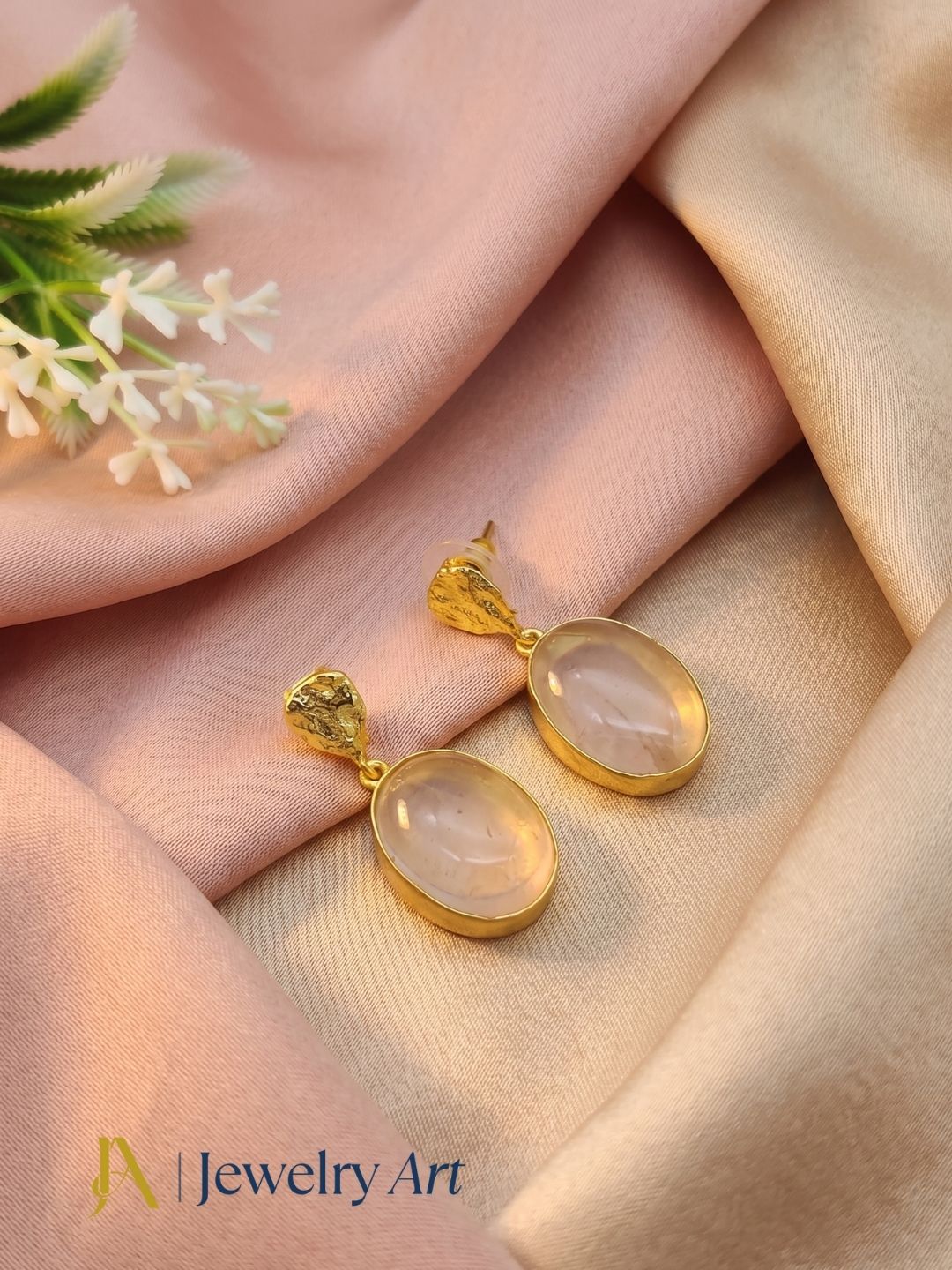 Premium rose quartz dangle earrings featured in decorative product photography
