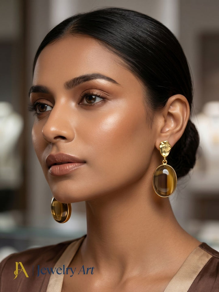 Woman wearing gold plated smoky quartz dangle earrings with elegant party wear styling
