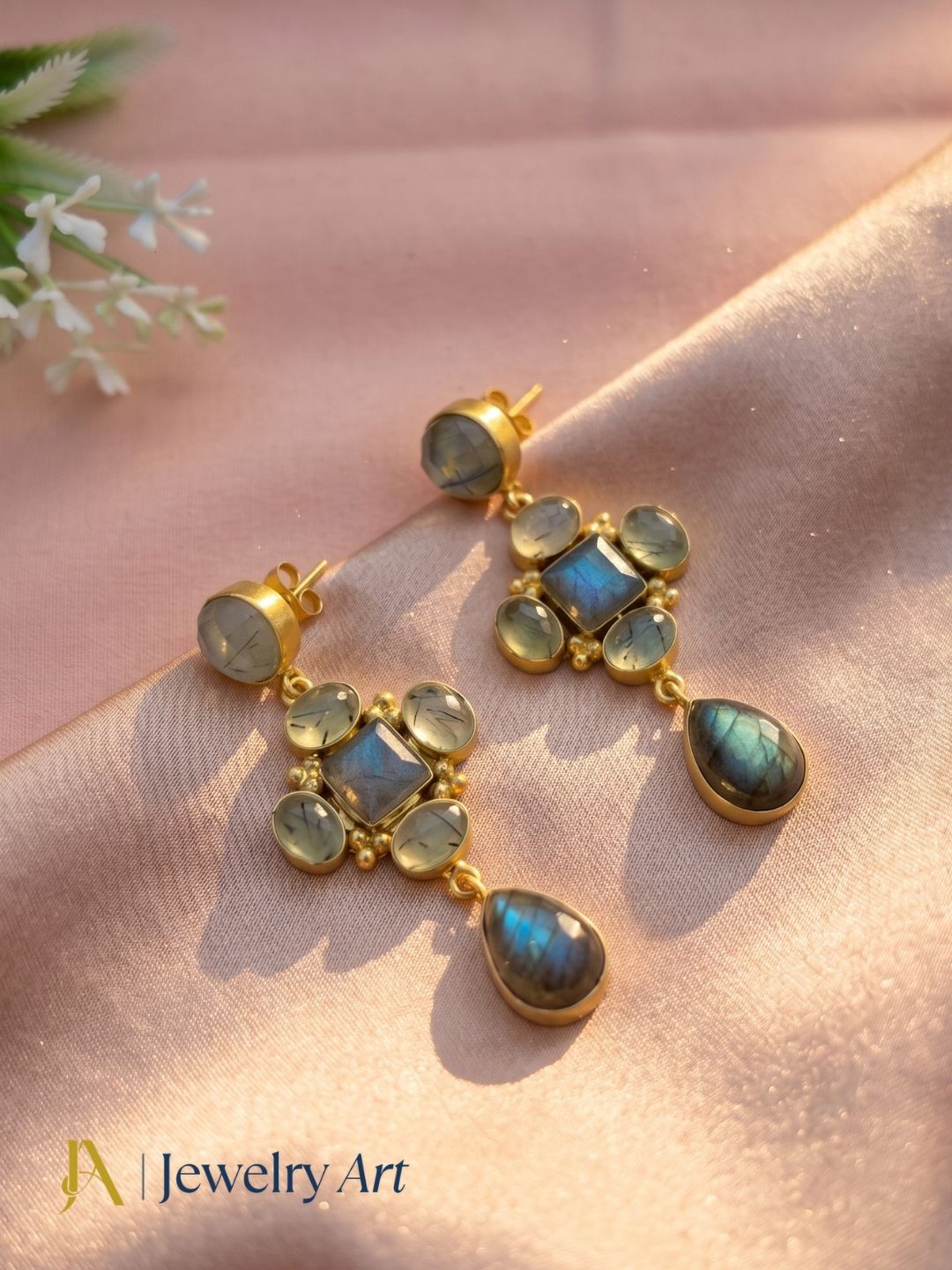 Designer gold plated labradorite prehnite earrings in artistic flat lay photography
