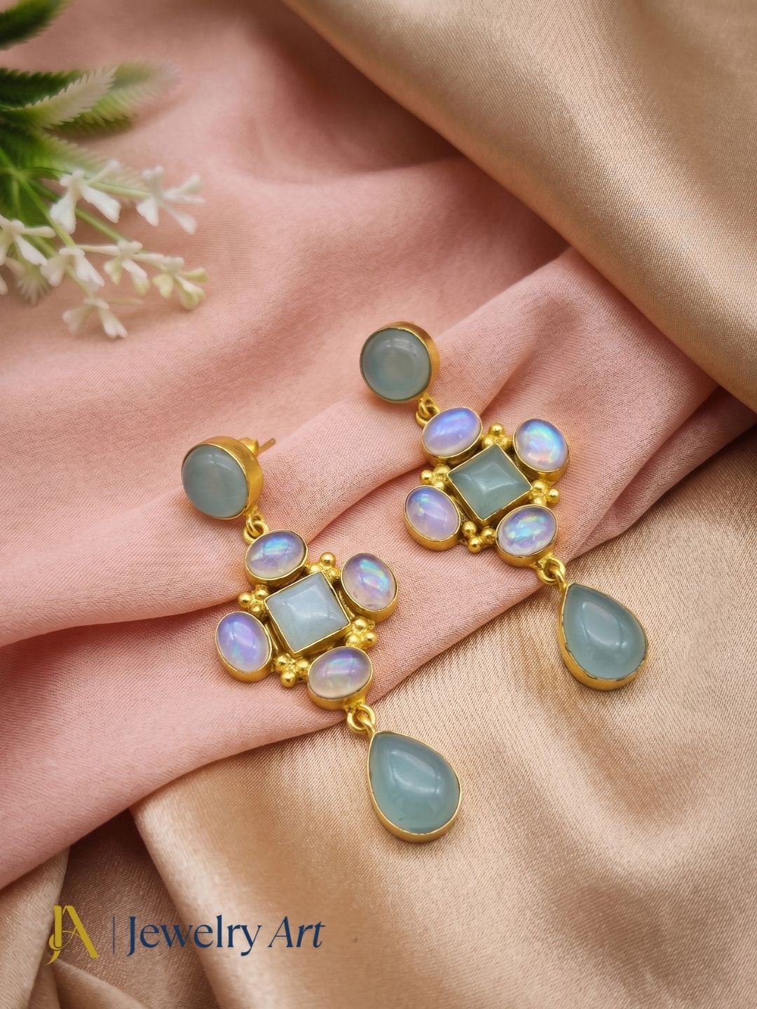 Artistic display of handcrafted aquamarine synthetic opal dangle earrings
