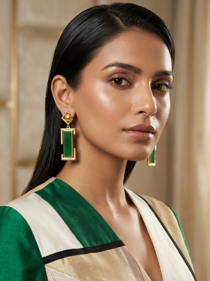 Woman wearing gold plated green onyx geometric drop earrings, elegant contemporary designer jewelry

