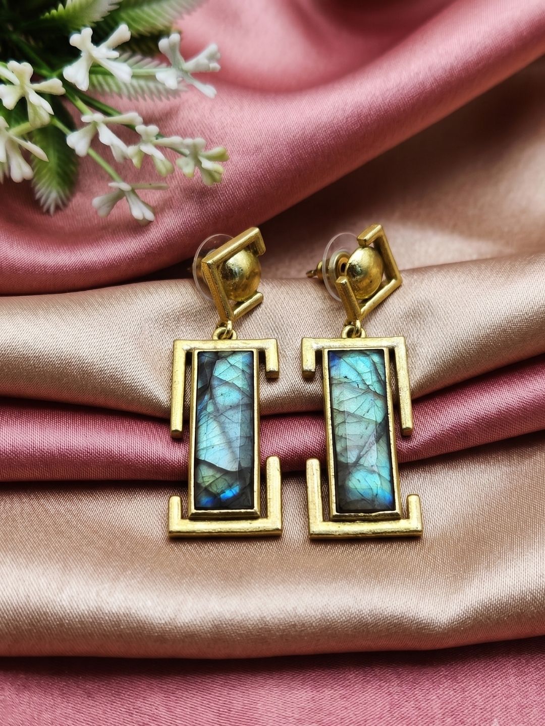 Handcrafted labradorite drop earrings displayed with luxury decorative styling
