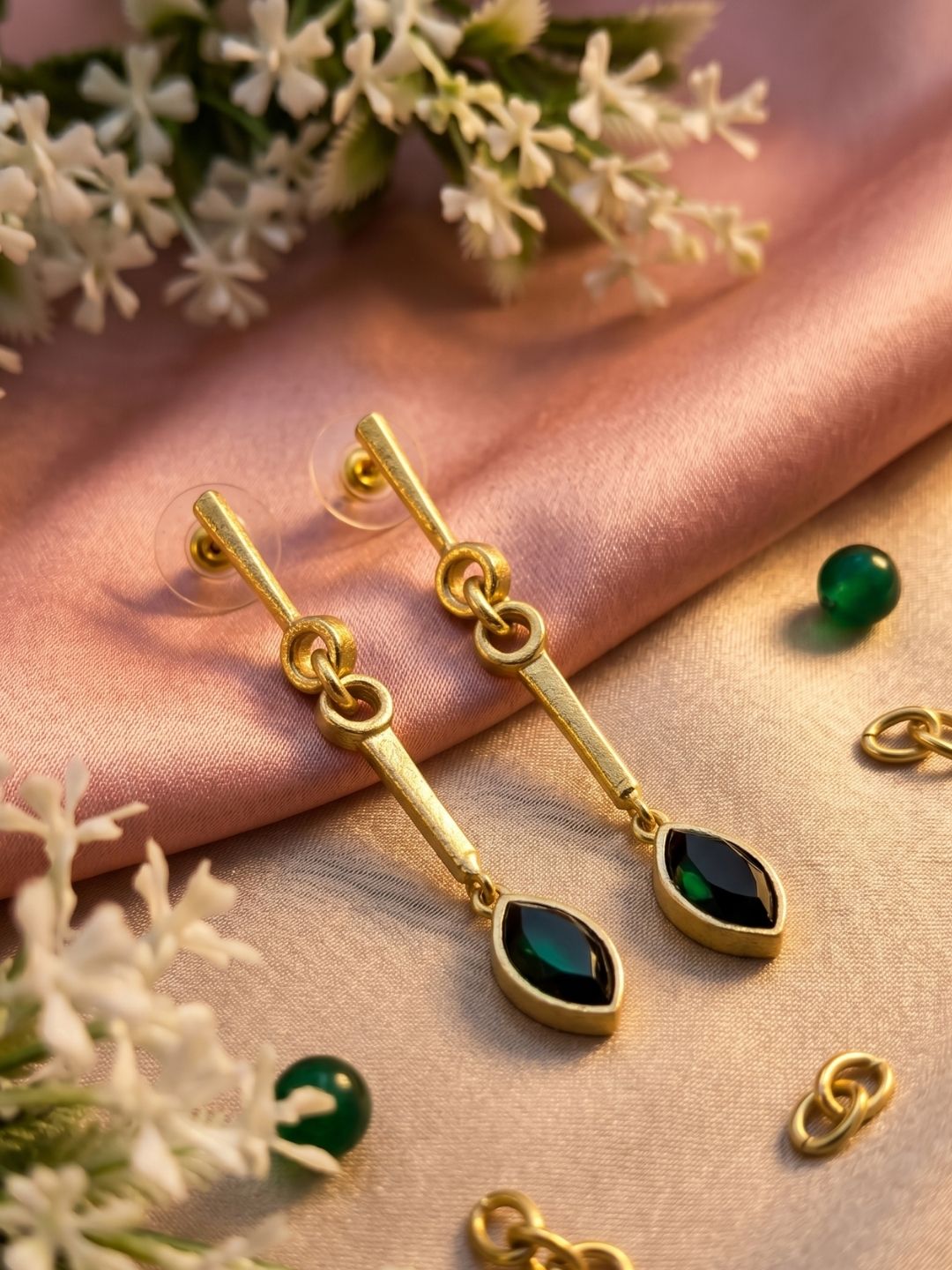 Premium green onyx drop earrings styled in a decorative jewelry shoot highlighting gemstone elegance.
