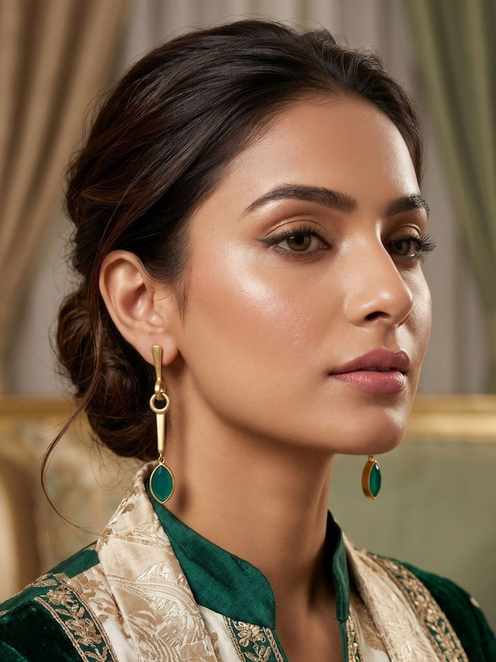 Woman styling green chalcedony gemstone long earrings with a chic and elegant outfit.
