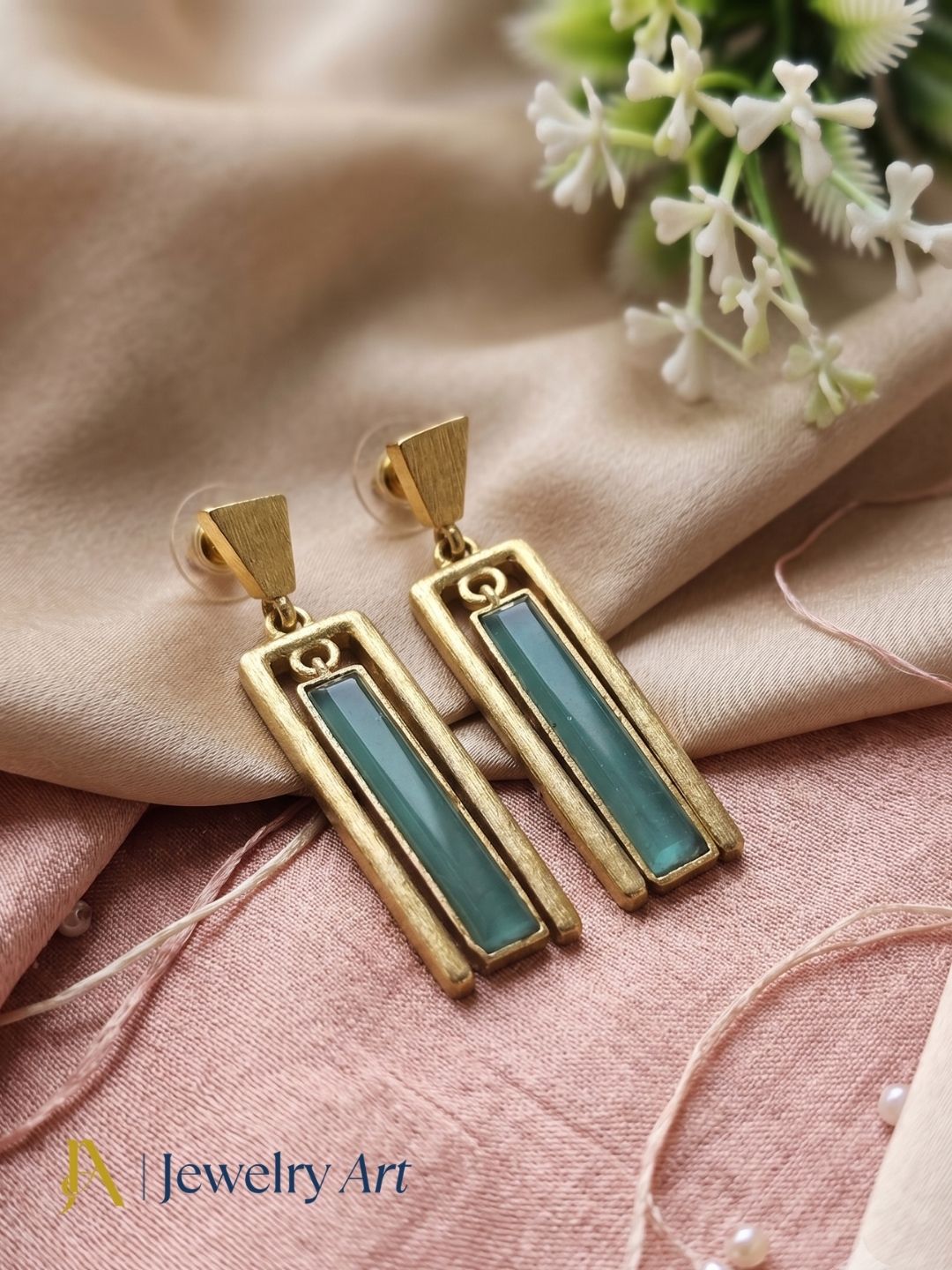 Gold plated aquamarine geometric dangle earrings styled with soft spring florals  
