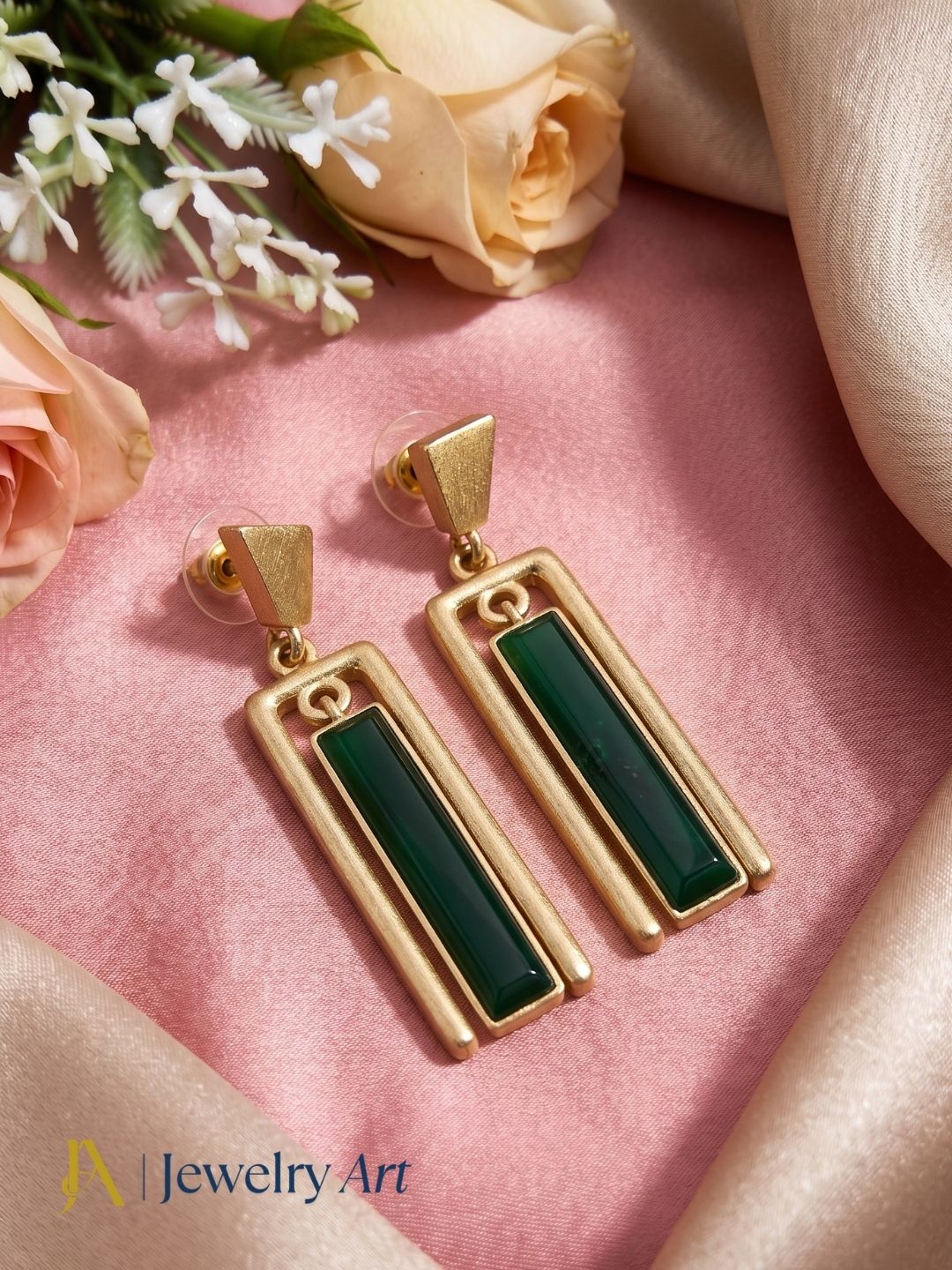 Premium aquamarine dangle earrings presented in a creative styling setup emphasizing gemstone elegance and artisan detailing.
