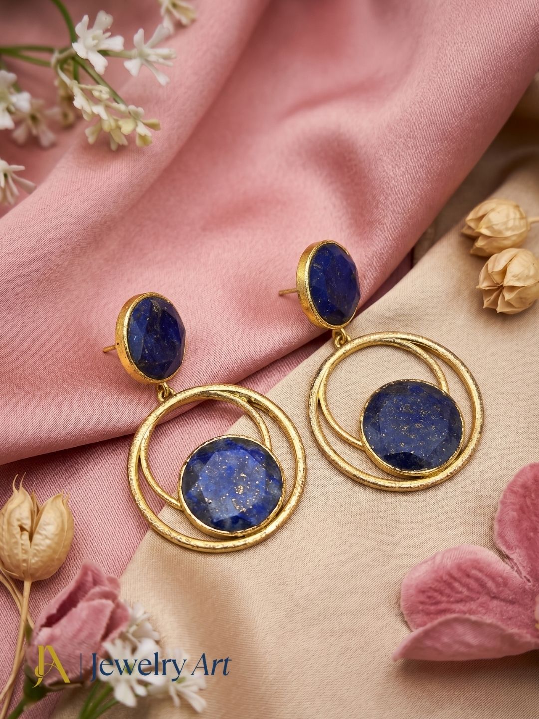Artistic flat lay of gold plated Lapis gemstone earrings

