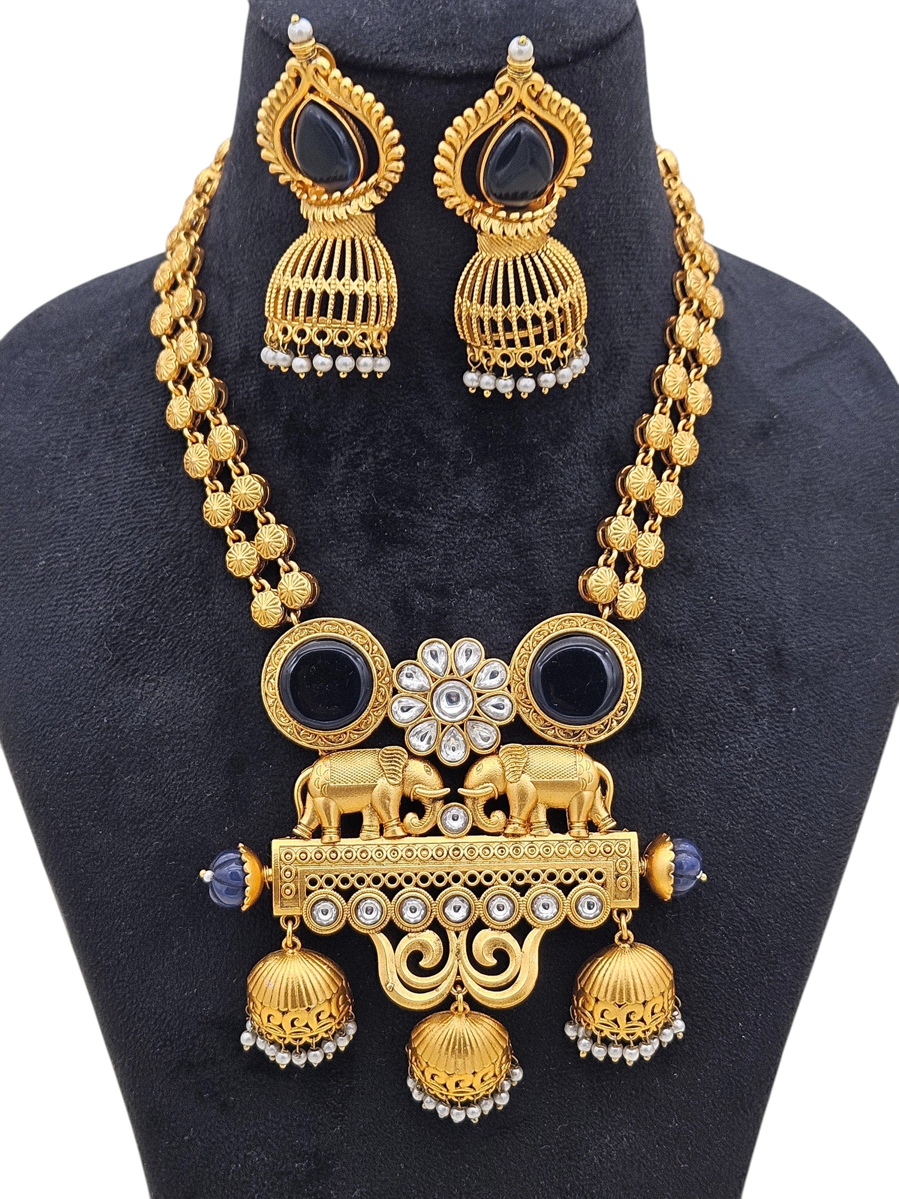 Detailed view of Polki necklace set in antique gold with blue Monalisa stones, pearls, and matching earrings
