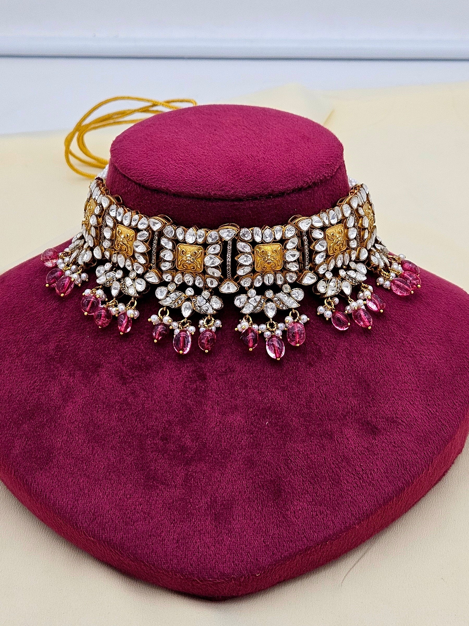 Designer red hydro quartz and polki choker necklace on neck stand – stylish Indian festive jewellery.
