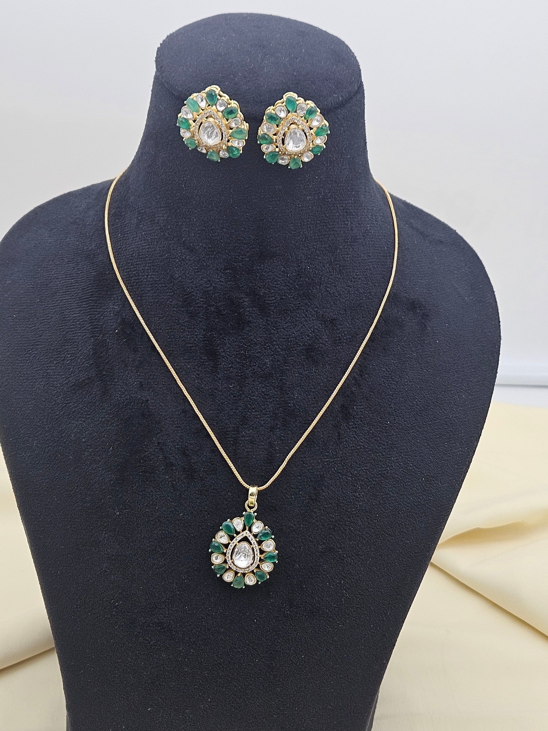 Elegant AD polki green hydro quartz pendant necklace set with earrings displayed on stand
