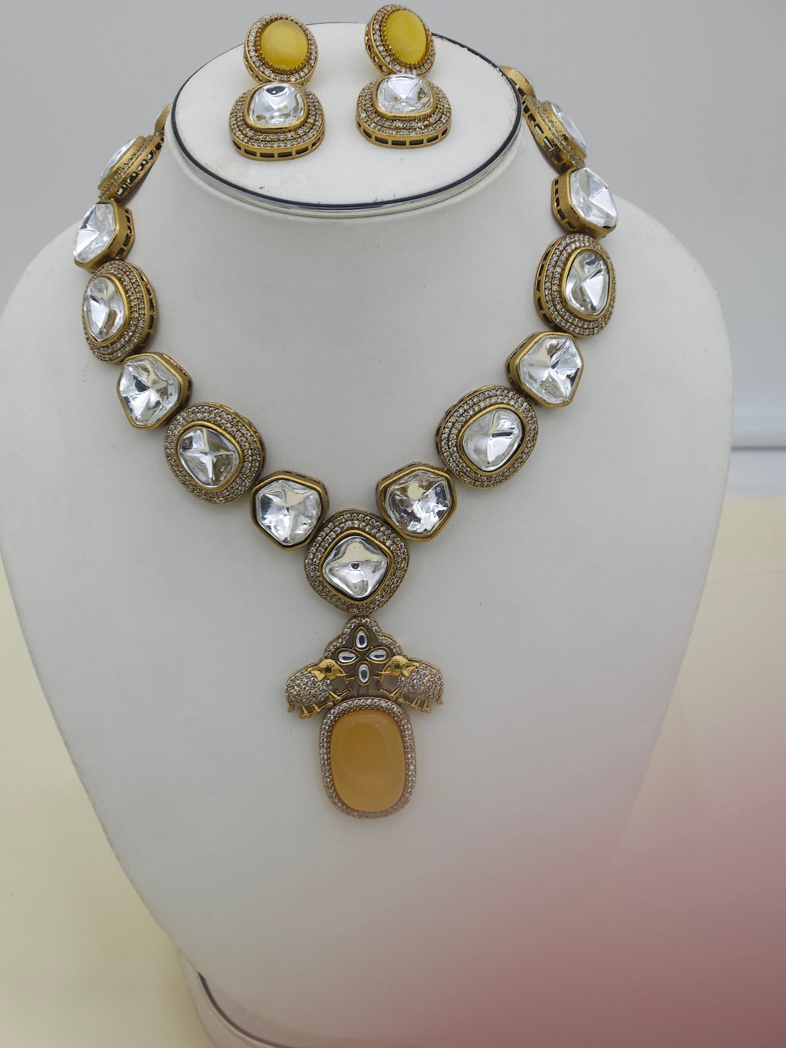 Traditional yet glamorous antique gold-plated necklace and earrings set with intricate Polky and American diamond embellishments
