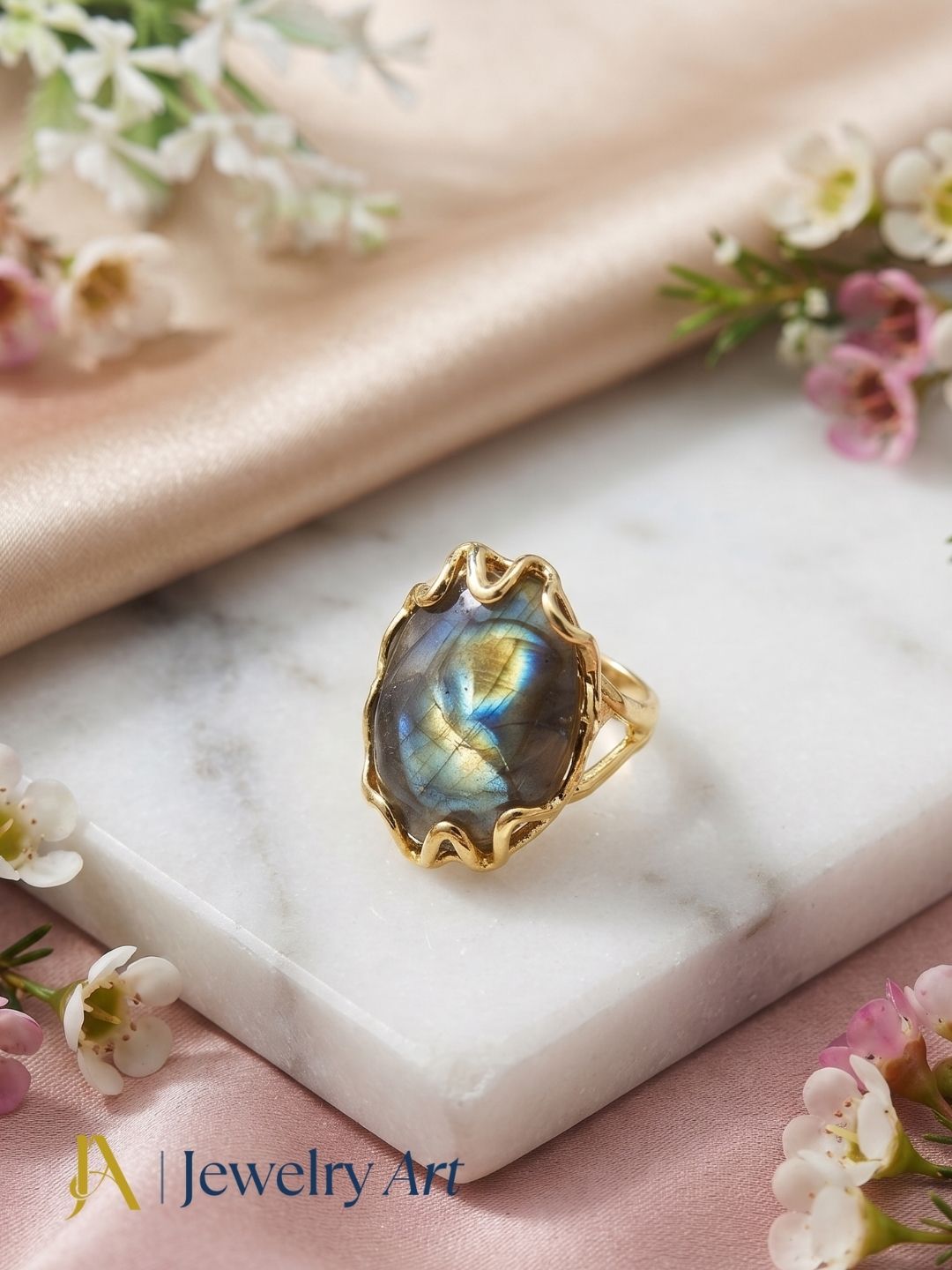 Gold plated handcrafted Labradorite gemstone ring displayed in a refined decorative jewelry arrangement with premium styling.
