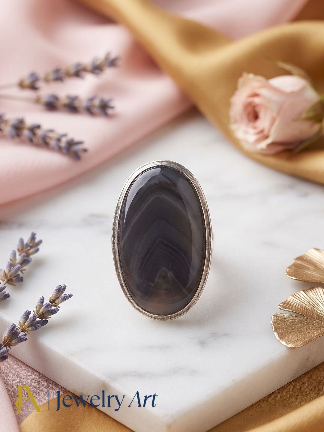 Handcrafted silver plated GS men's Agate stone statement ring displayed in a luxury decorative jewelry setup with elegant props, highlighting the natural gemstone and artisan craftsmanship.
