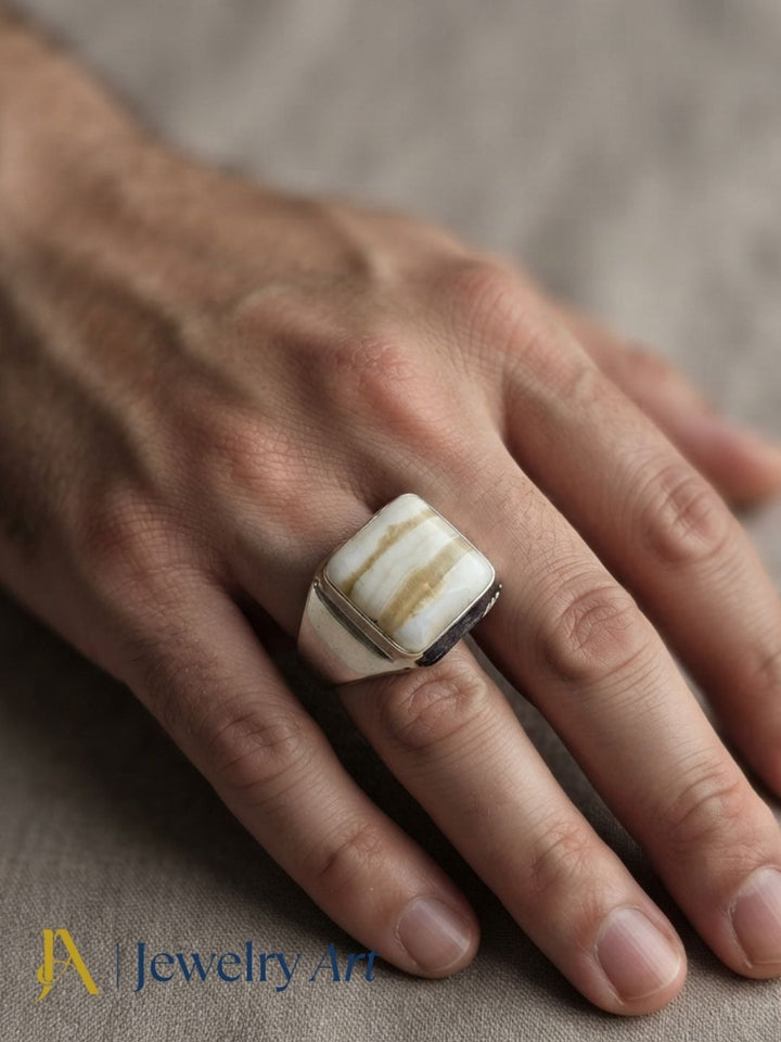 Hand model displaying a natural Jasper gemstone ring with a handcrafted silver plated GS designer setting.
