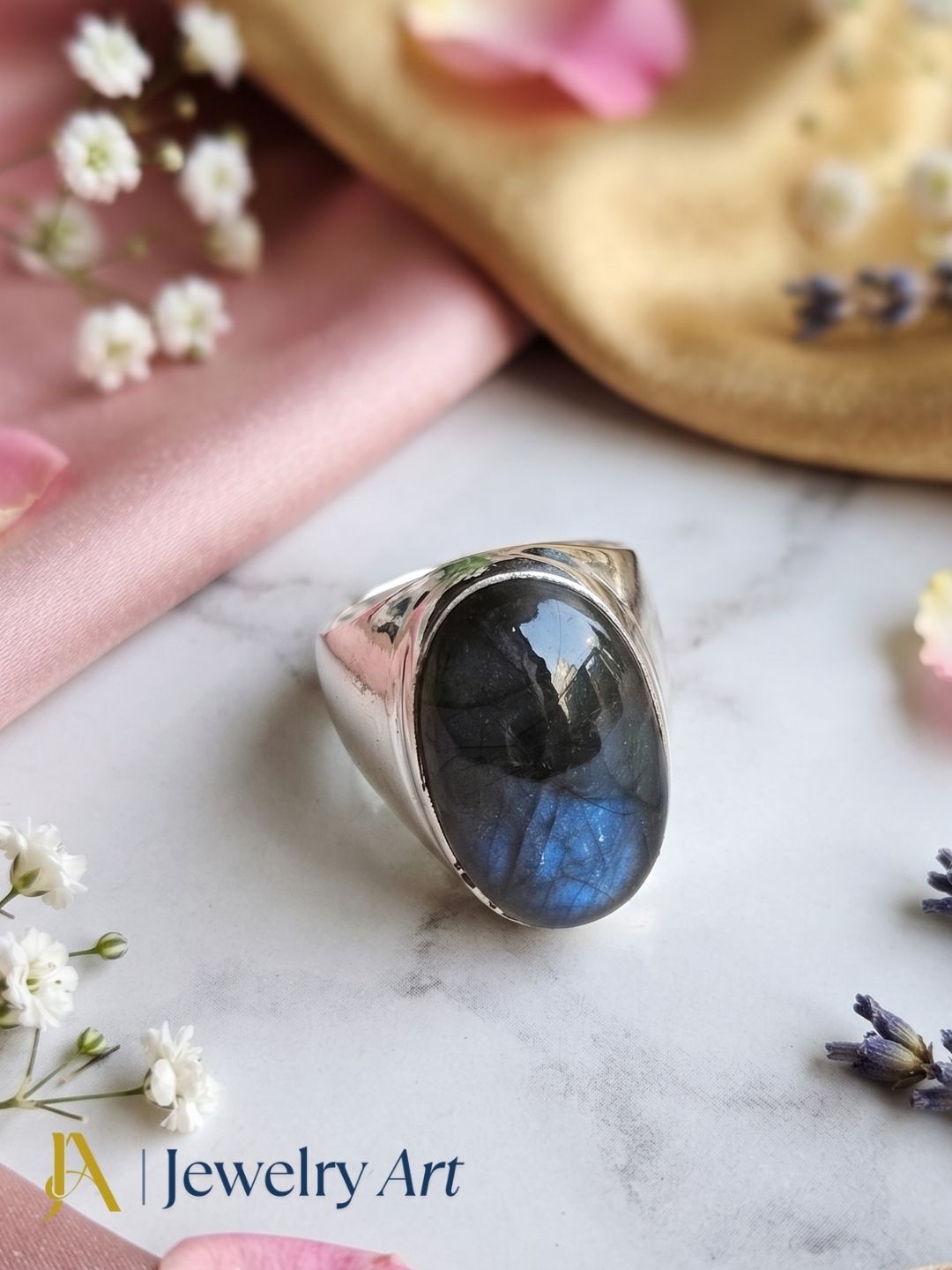 Natural Labradorite gemstone ring in silver plated GS displayed in a refined decorative jewelry arrangement.
