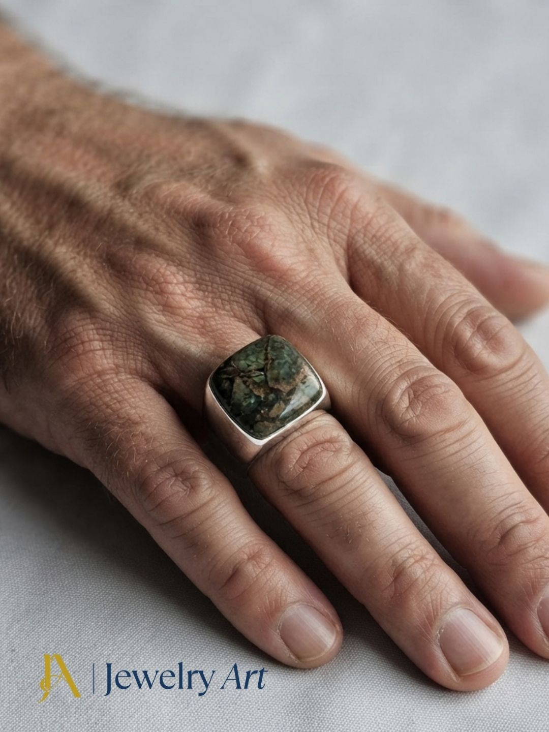 Stylish man wearing a handmade Copper Chrysocola stone ring in silver plated GS for a premium men's fashion jewelry photoshoot.
