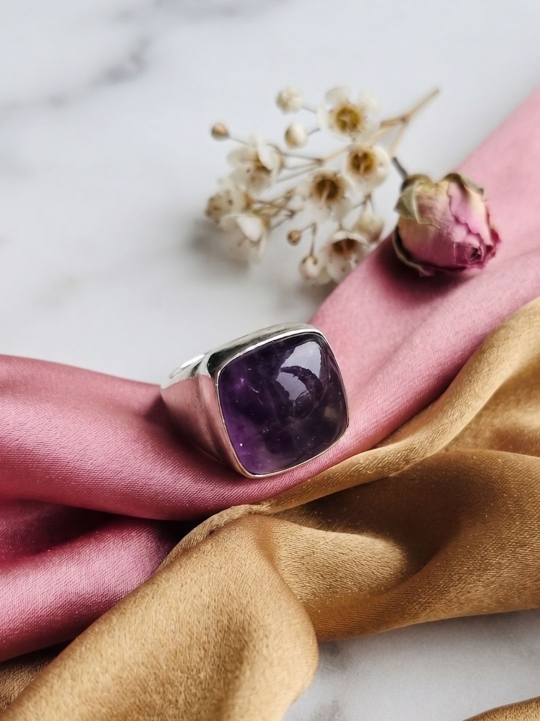 Designer Natural Amethyst ring displayed with elegant decorative props
