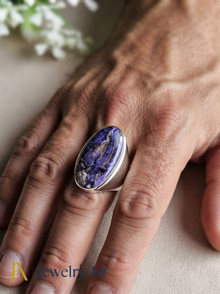 Fashion model showcasing a natural Charoite gemstone handcrafted silver plated GS designer statement ring with a contemporary look.
