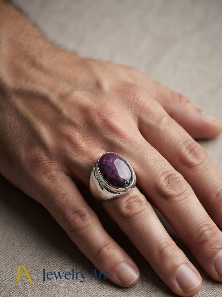 Close-up of a man's hand wearing a natural Ruby Zoisite gemstone Silver Overlay GS ring showcasing artisan craftsmanship and elegant design.
