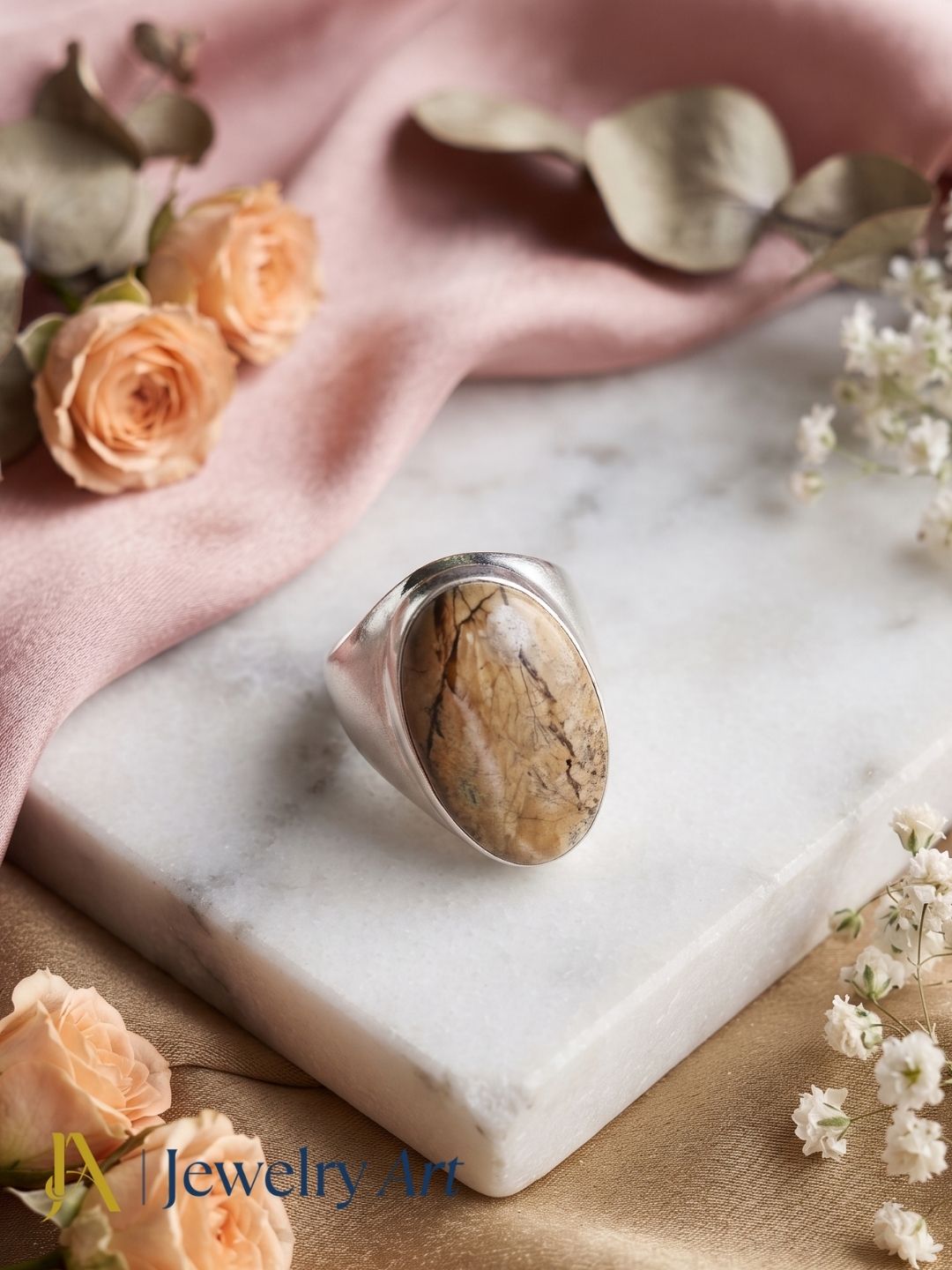 Premium Picture Jasper stone men's ring styled with elegant decorative props for luxury product photography.
