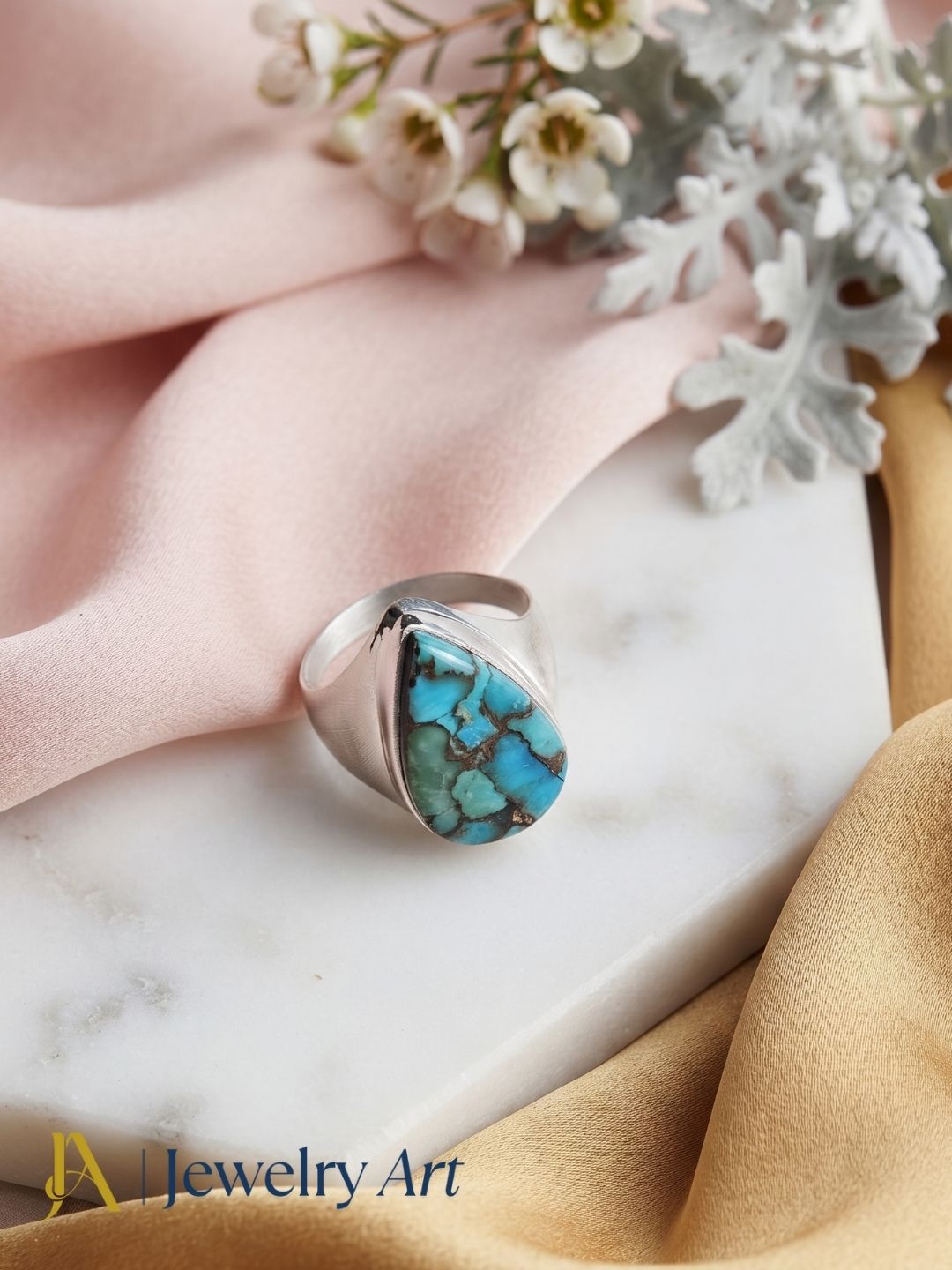 Premium Copper Turquoise stone men's statement ring styled with elegant decorative props for luxury product photography.

