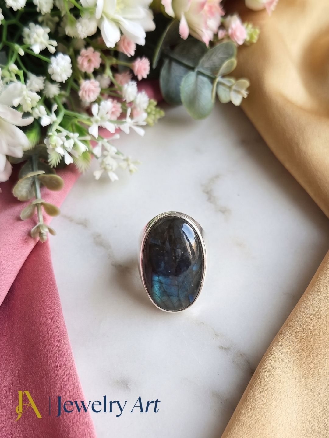 Luxury flat lay featuring a handcrafted natural Labradorite gemstone fashion ring for men with elegant presentation.
