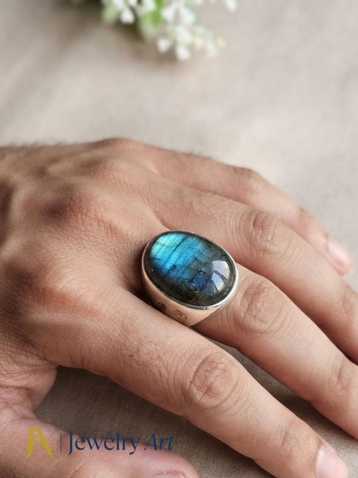 Hand model displaying a handcrafted Labradorite gemstone ring with premium silver plated GS artisan craftsmanship.
