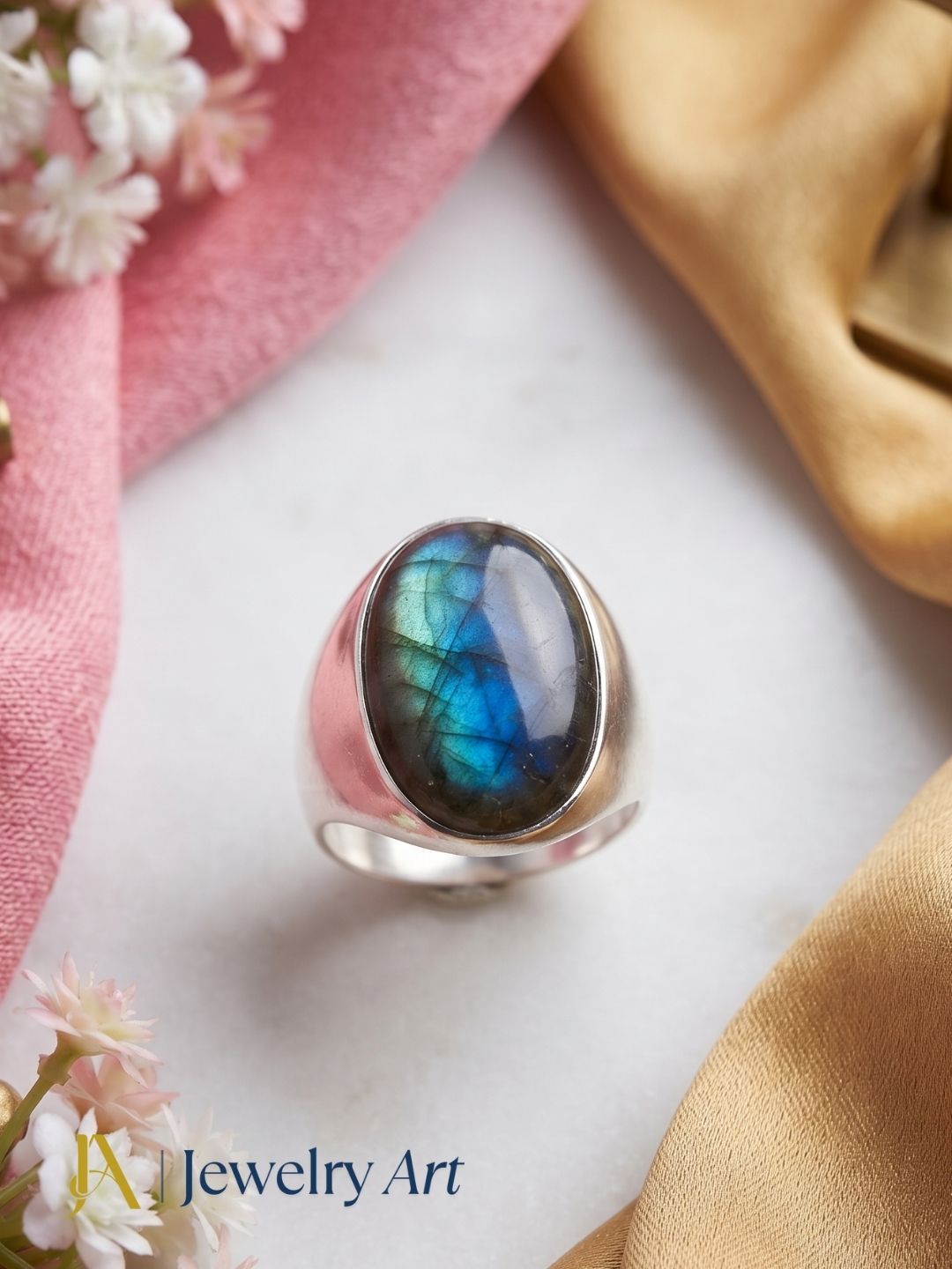 Editorial-style decorative photography featuring a handcrafted natural Labradorite gemstone men's fashion ring.
