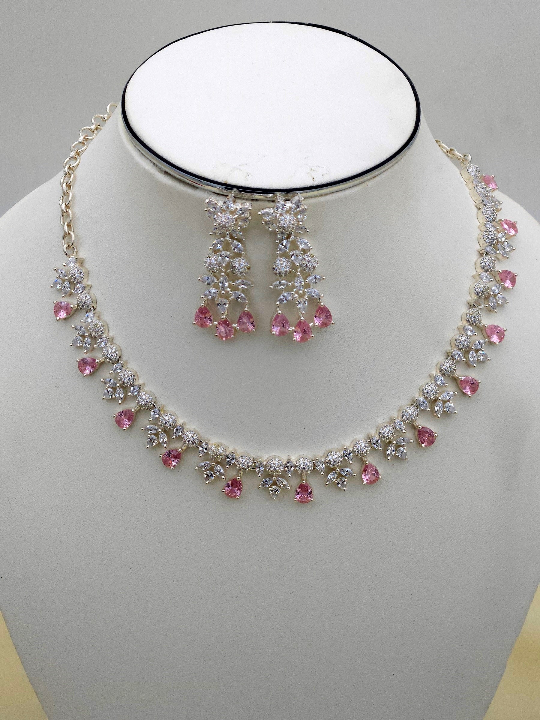 Macro shot of rhodium plated silver necklace and earrings featuring pink hydro quartz and cubic zirconia stones
