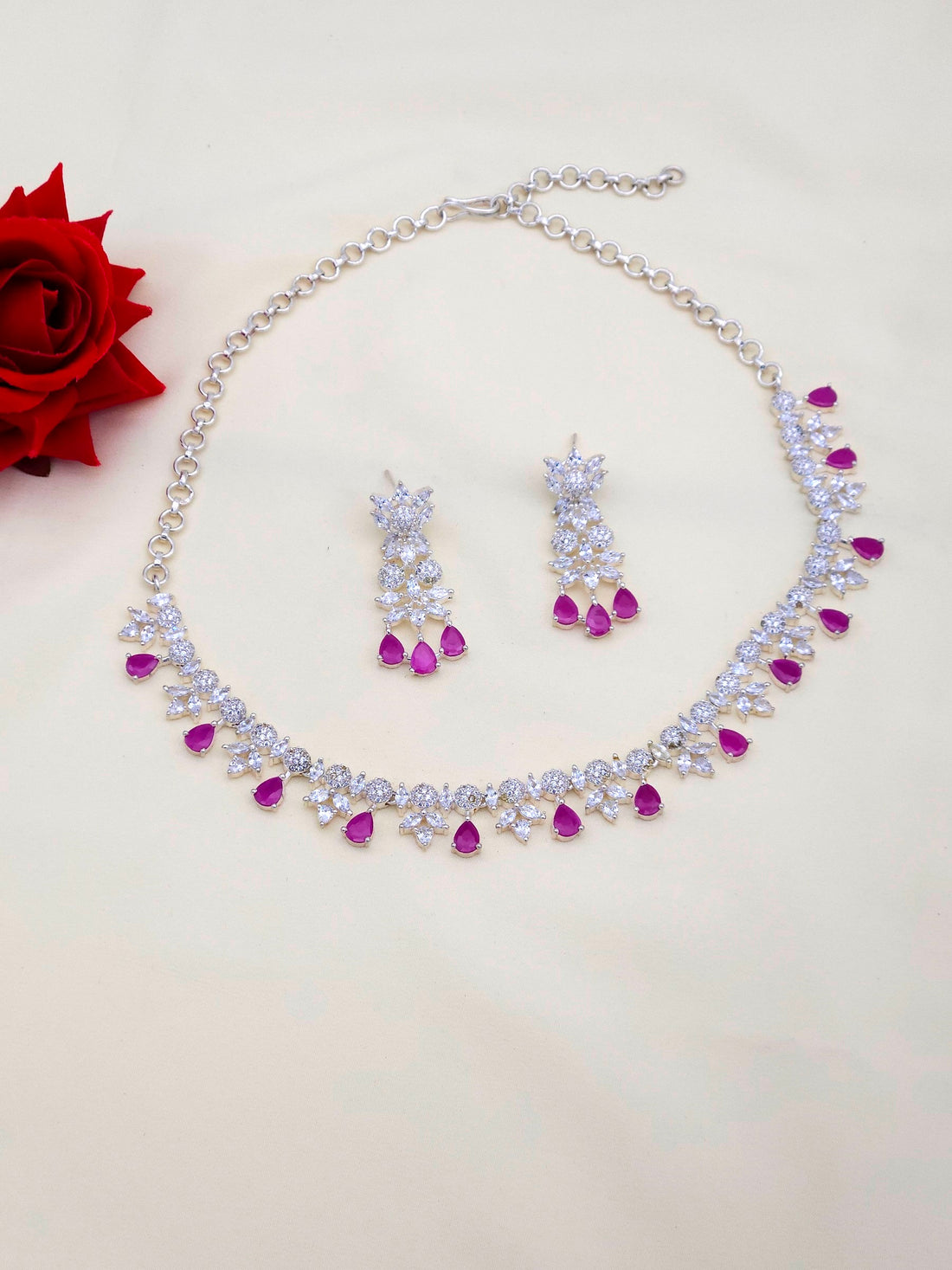 Rhodium plated silver necklace and matching earrings with red beryl and sparkling CZ stones in designer style
