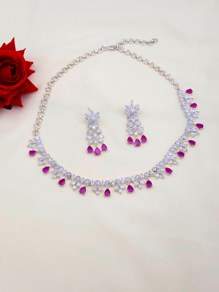 Rhodium plated silver necklace and matching earrings with red beryl and sparkling CZ stones in designer style
