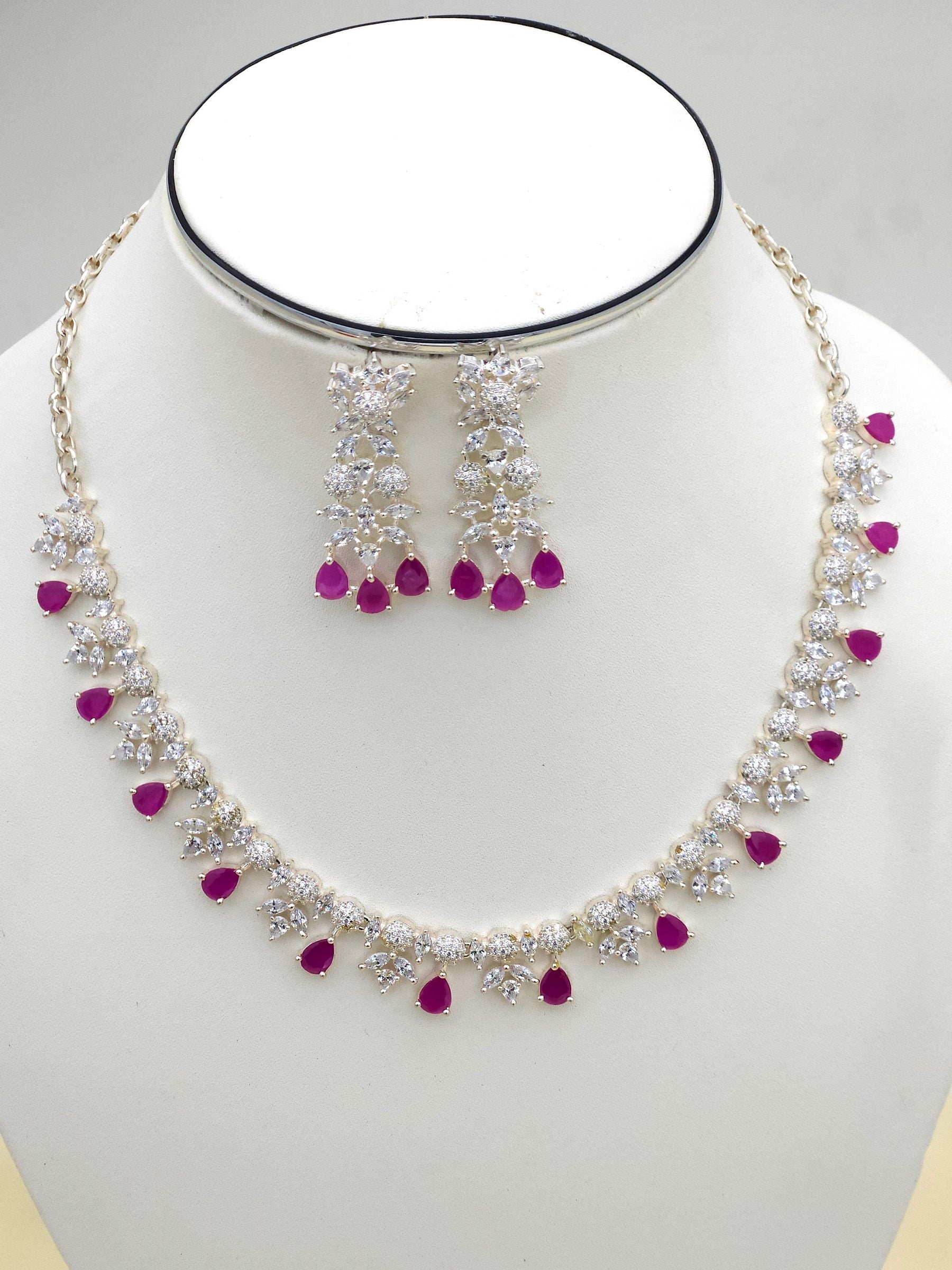 Elegant rhodium plated silver jewelry set featuring red beryl and high-shine CZ stones
