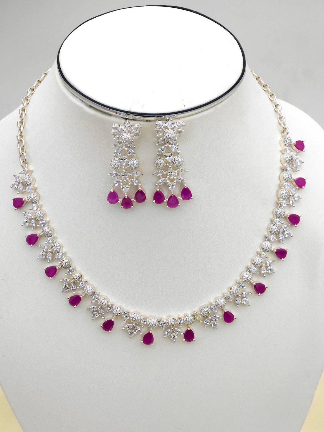 Elegant rhodium plated silver jewelry set featuring red beryl and high-shine CZ stones
