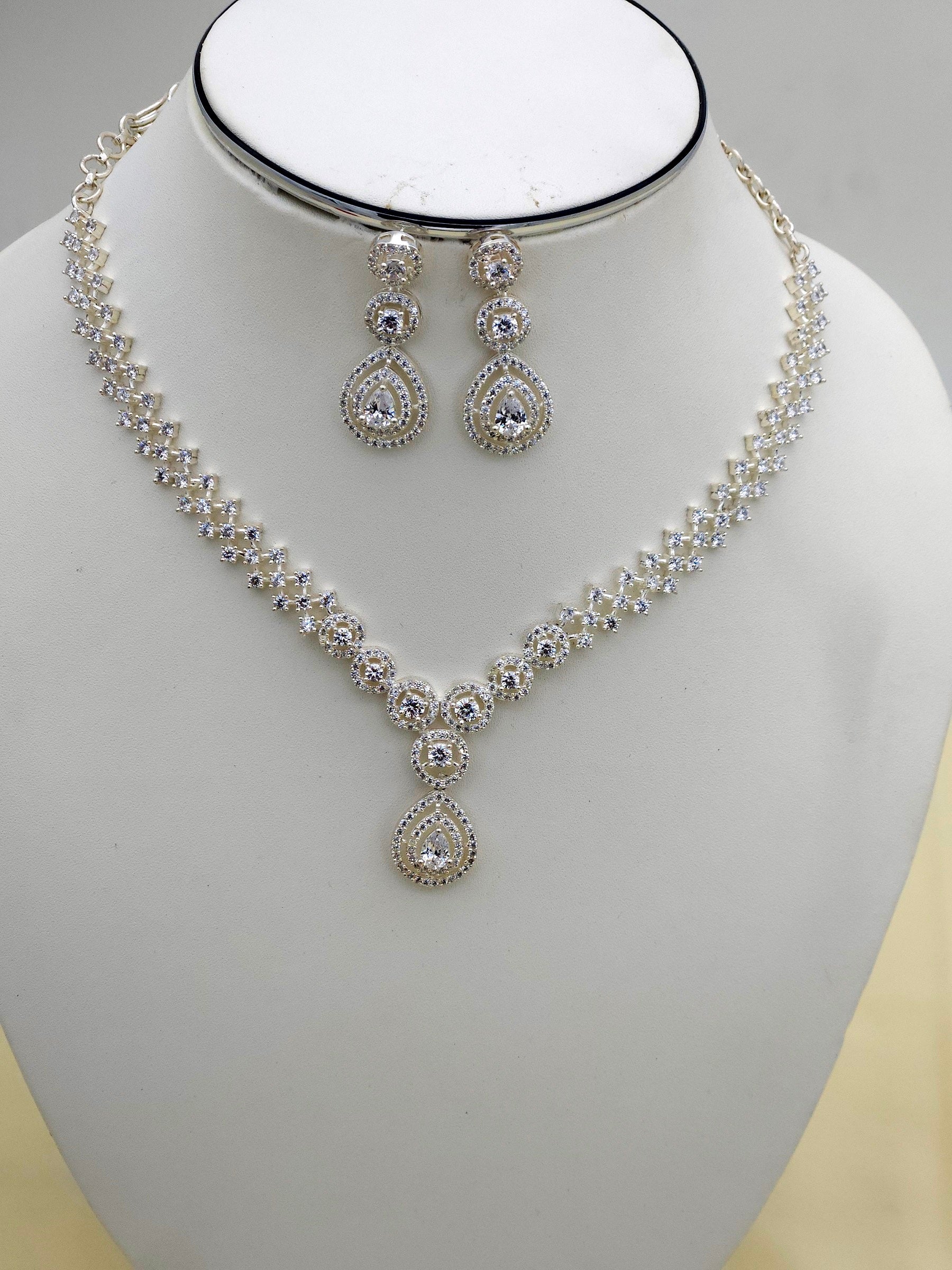 Close-up of rhodium plated silver jewelry set with cubic zirconia necklace and earrings – designer finish
