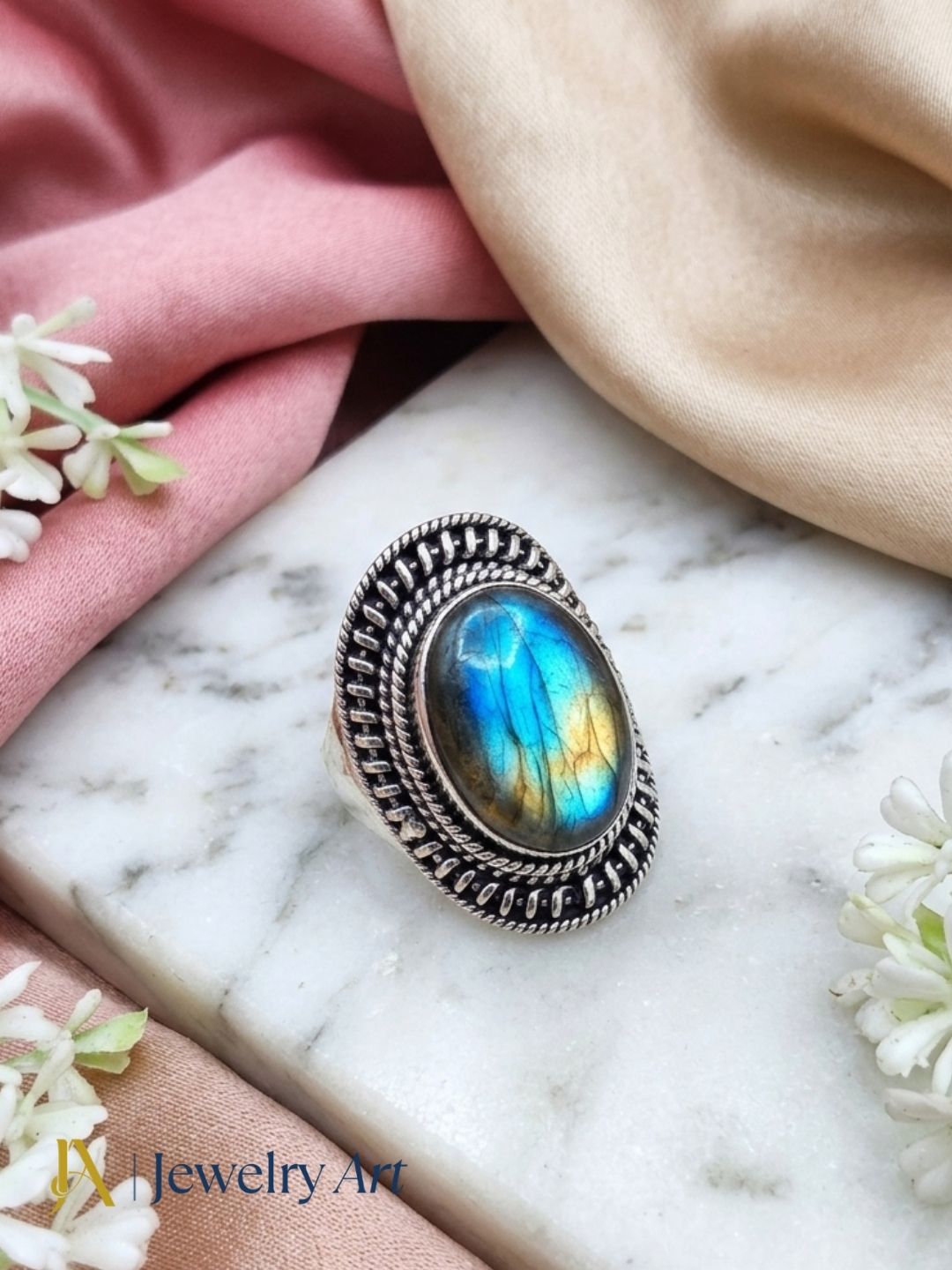 Designer Labradorite silver ring displayed with elegant decorative props

